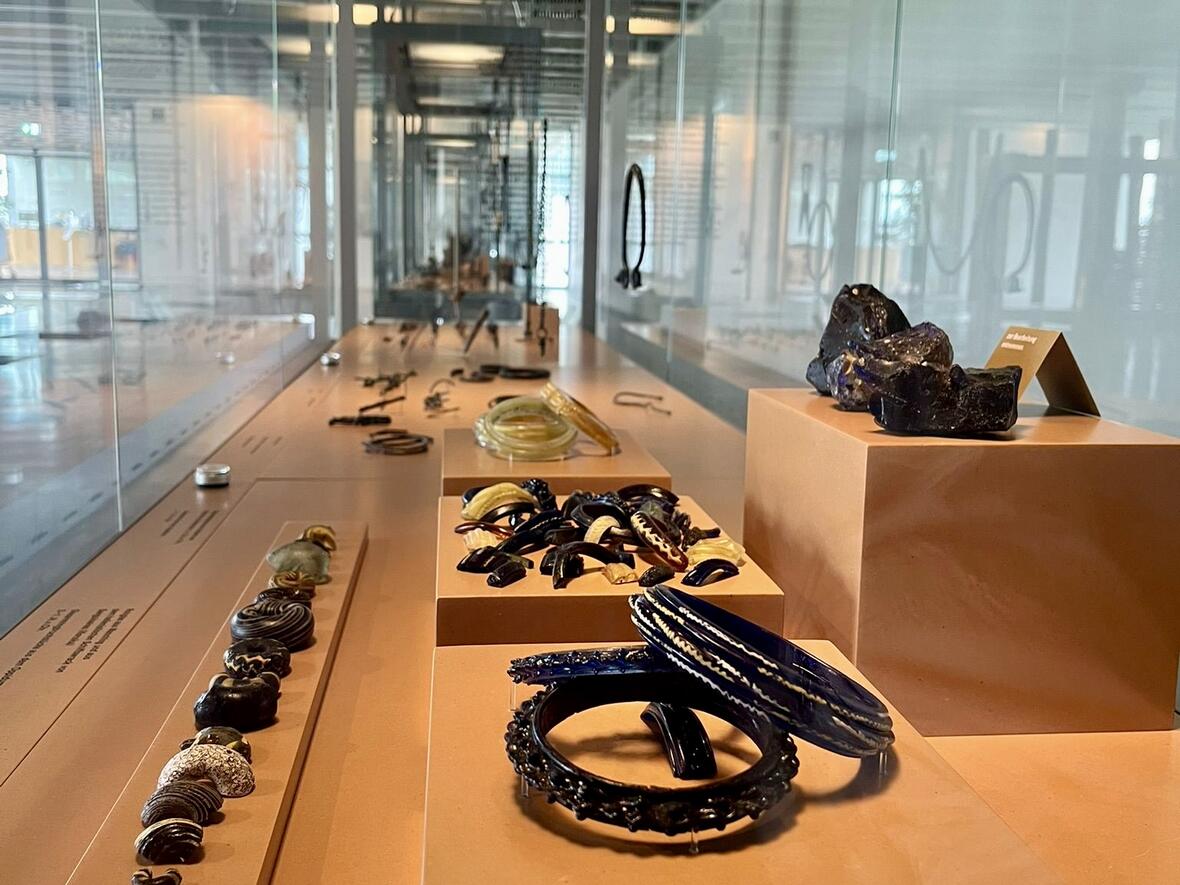 Historischer Schmuck in Vitrinen im Museum, verschiedene Armreifen und Halsketten auf Ausstellungsflächen.
