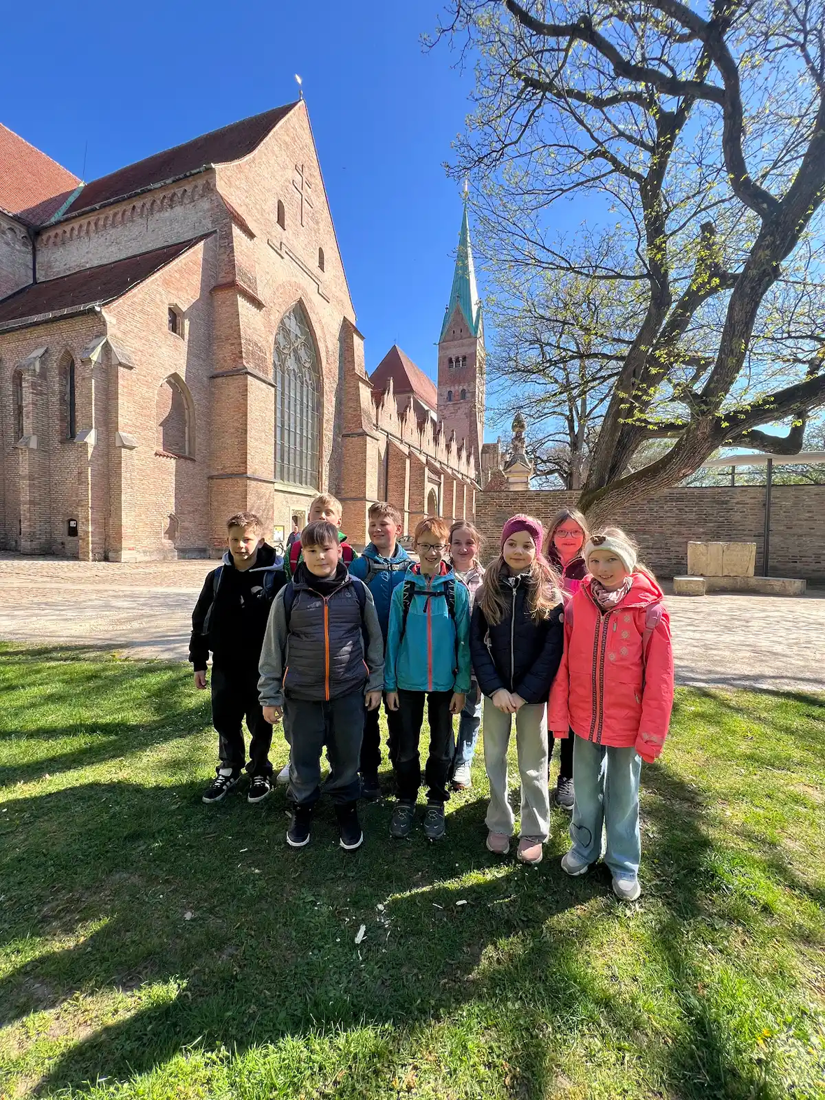 Gruppe von Kindern vor der St. Marienkirche in Lübeck an einem sonnigen Tag.